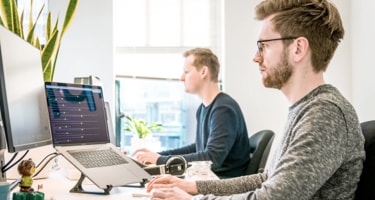 Two man sitting and working on computer in the office